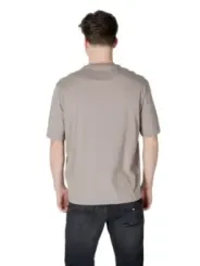 Mann trägt beiges T-Shirt und Jeans